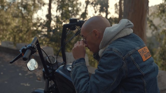 A motorcyclist putting on his hood and sunglasses