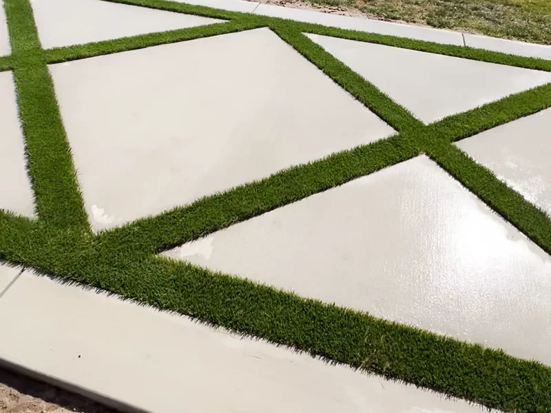 Modern concrete pavers with artificial turf inlay creating diamond pattern
