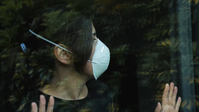 Woman taking her mask off