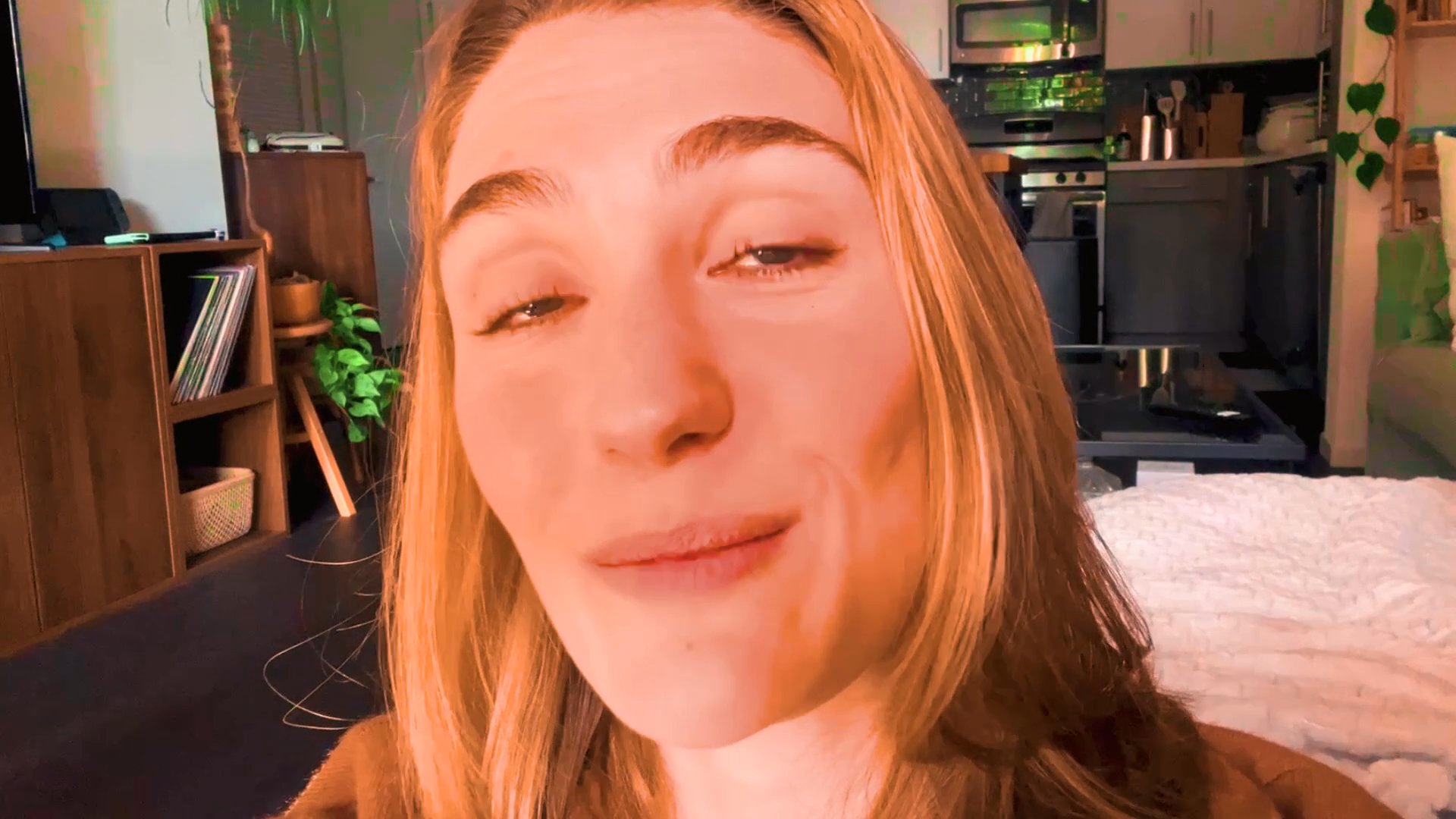 A woman speaks directly to the camera in a conversational, reflective tone, sharing thoughts or observations in a domestic interior setting.
