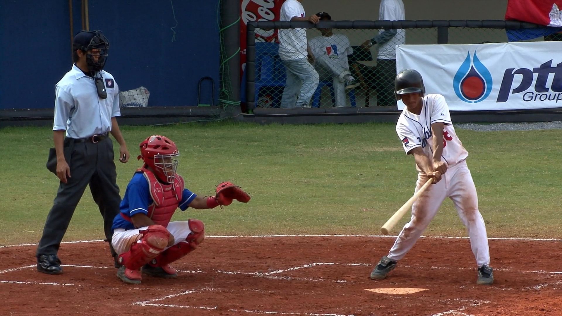 Athletes compete in a baseball game at a stadium, featuring pitching, batting, and strategic plays on the field. Coaches and spectators watch from the dugout as the match unfolds.
