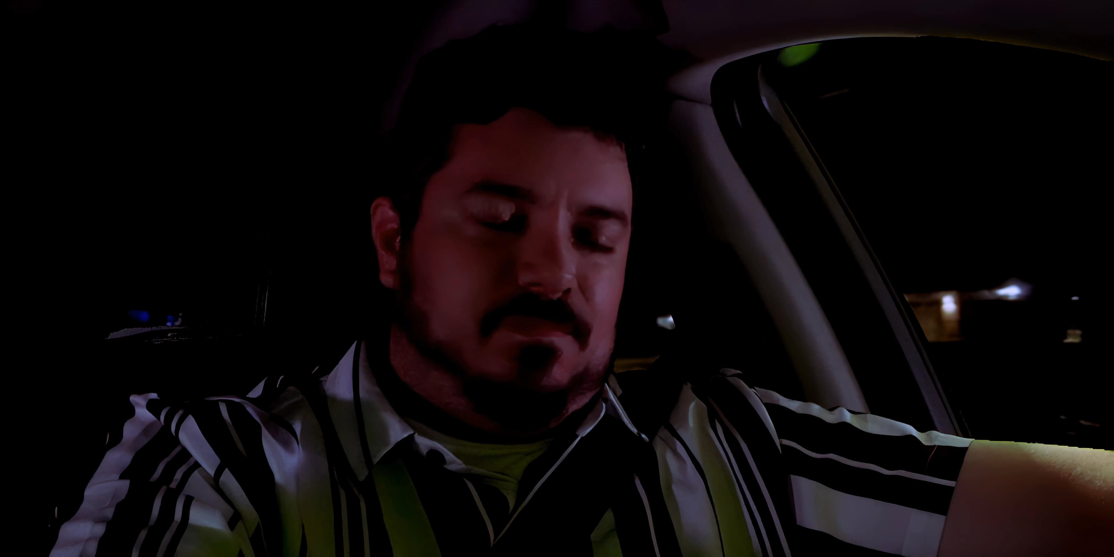 A man sits in the driver's seat of a car at night while his phone, mounted on the dashboard, displays an incoming call from Kate.
