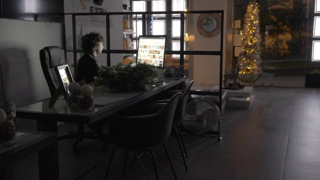 A guy working in an office that is decorated for Christmas