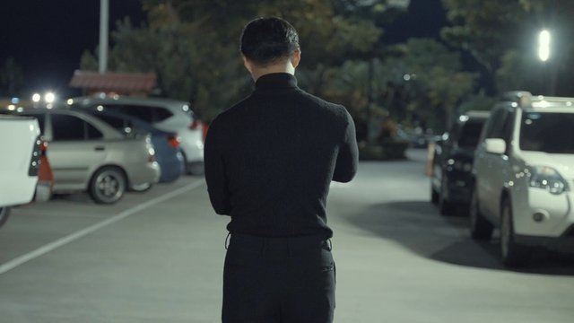 Man putting on a shirt while walking in the street