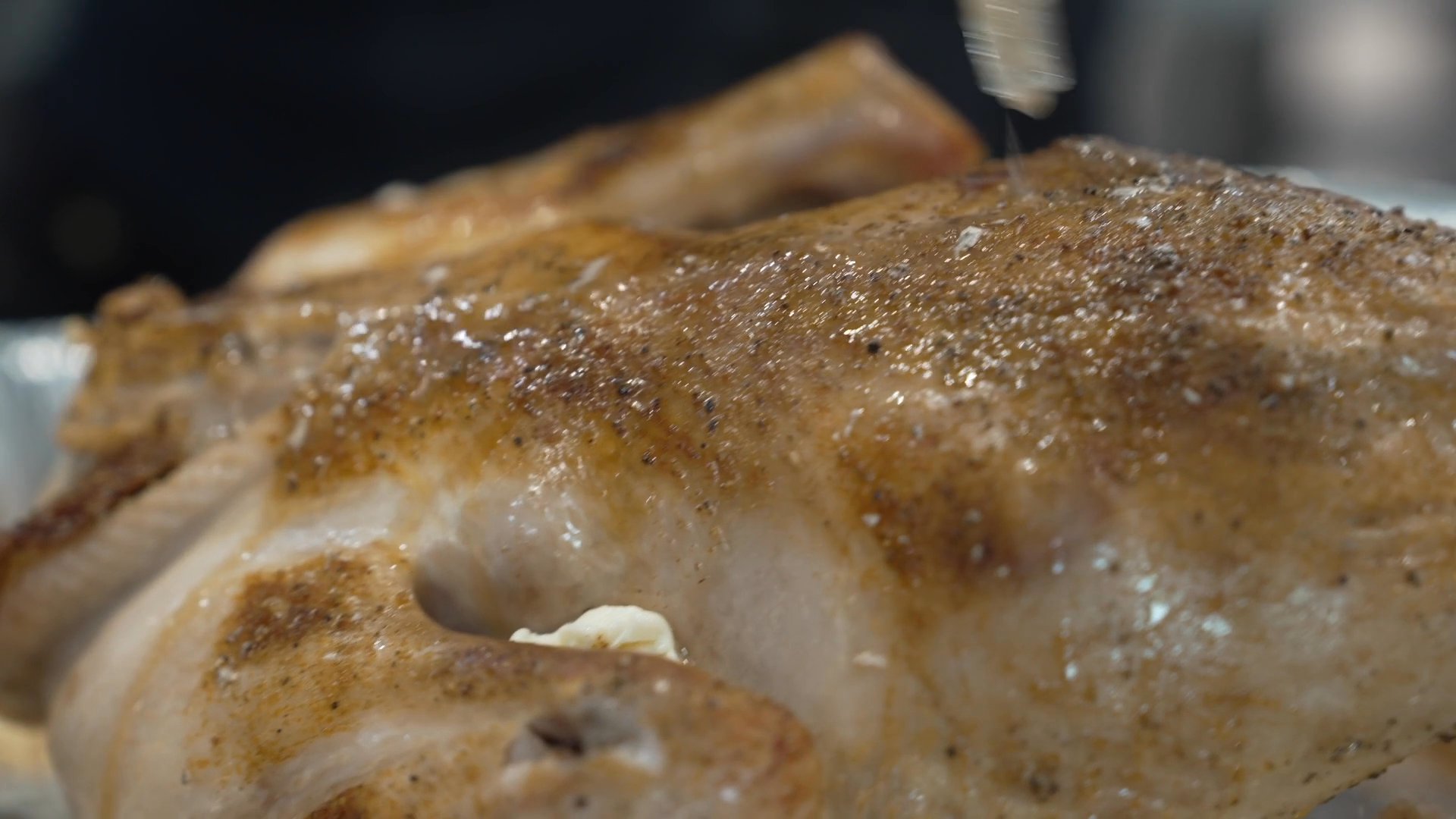 A host prepares a roast chicken dinner with side dishes, culminating in a group of friends and family gathering to dine and share wine.