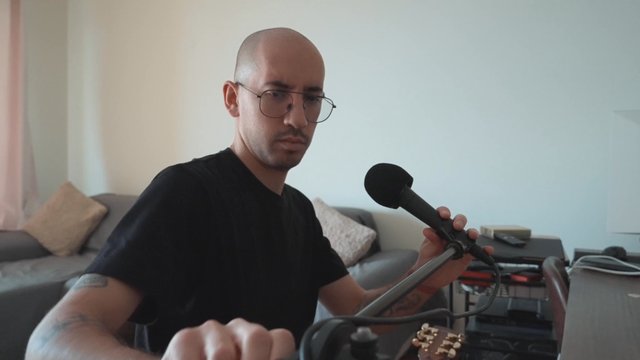 A guy fixes a flexible desk stand for his studio microphone