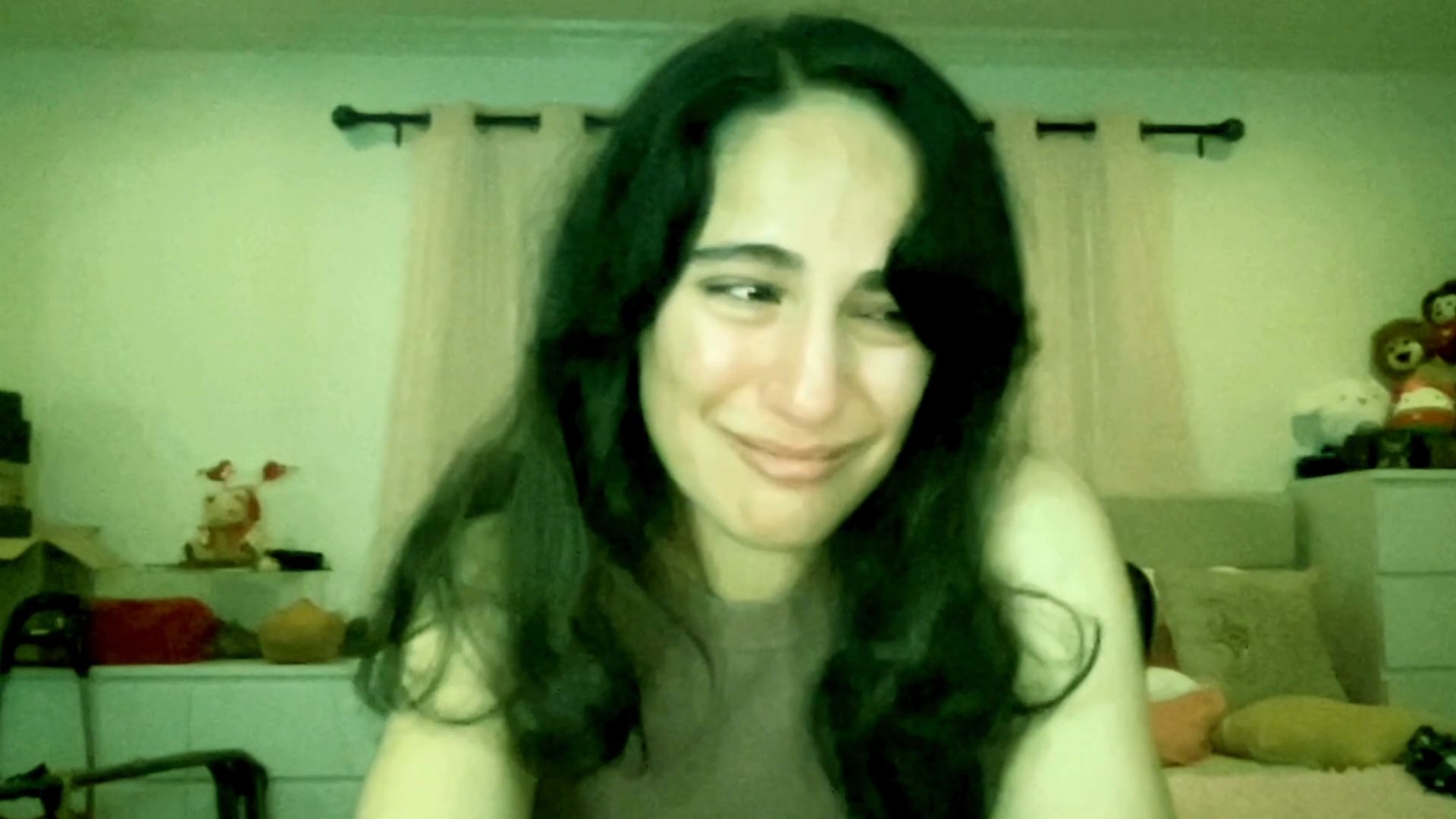 A woman shares an emotional experience while speaking directly to the camera in a residential setting. Her facial expressions convey a progression of sorrow, reflection, and tentative resilience.