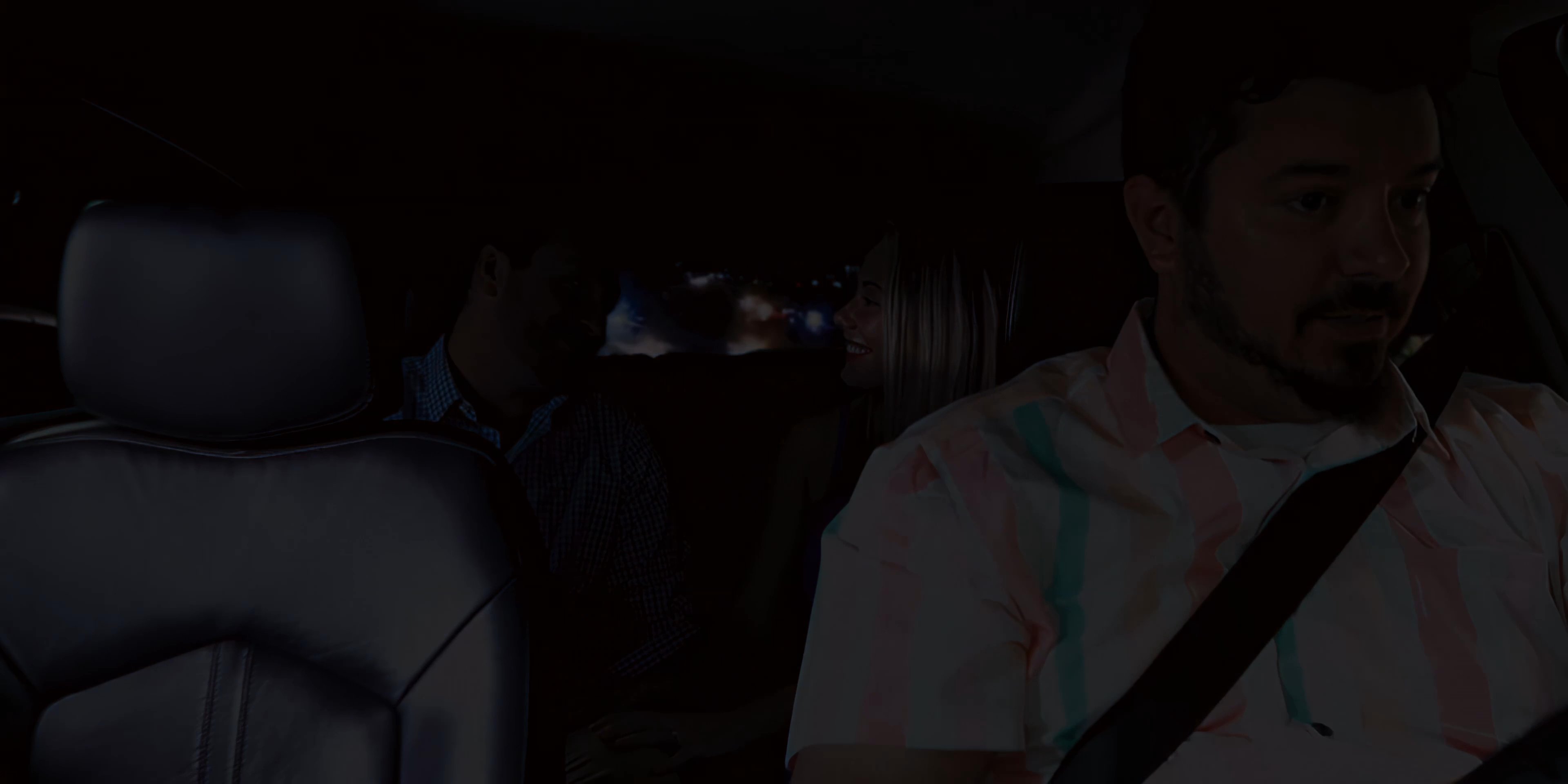 A man converses with passengers while driving through an illuminated city at night before returning home to prepare a cocktail. The sequence transitions from the interior of a vehicle to a quiet domestic setting.