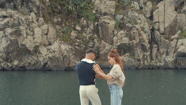 A girl straightening her boyfriend's shirt