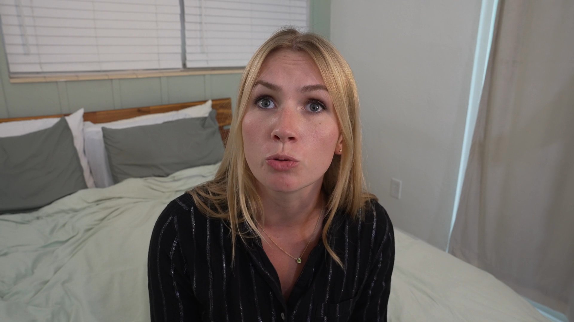 A woman speaks directly to the camera in a bedroom setting, interspersed with sequences of her engaged in a tense conversation with a man.