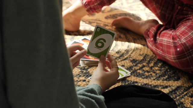 A daughter wins a game of UNO against her mom