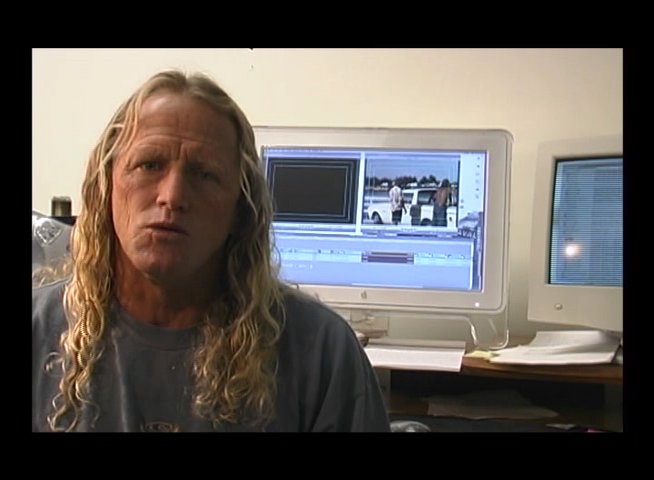 A surfer demonstrates wave riding techniques on the water, followed by an expert providing professional commentary and analysis in an indoor office setting.