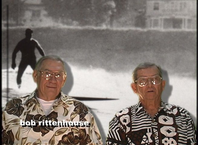 An individual reflects on their experiences as a surfer while historical footage plays in the background, detailing past milestones and personal history.