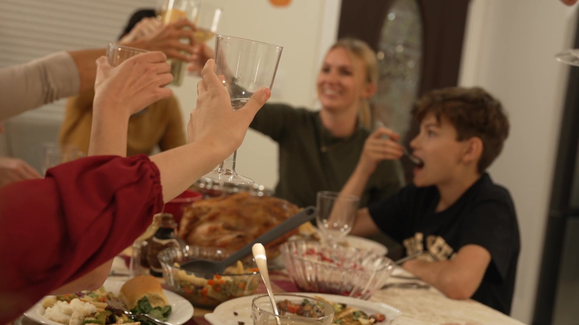 A family shares a meal and casual moments together in their home during a holiday celebration. The scenes transition between private reflection and group dining activities.