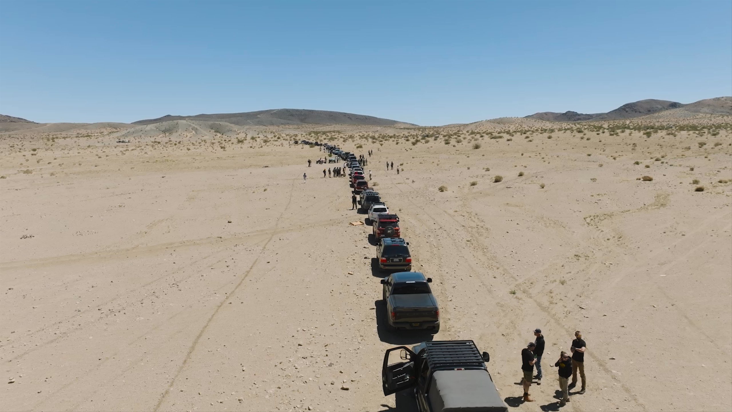 Aerial video over caravan of trucks in Joshua Tree desert