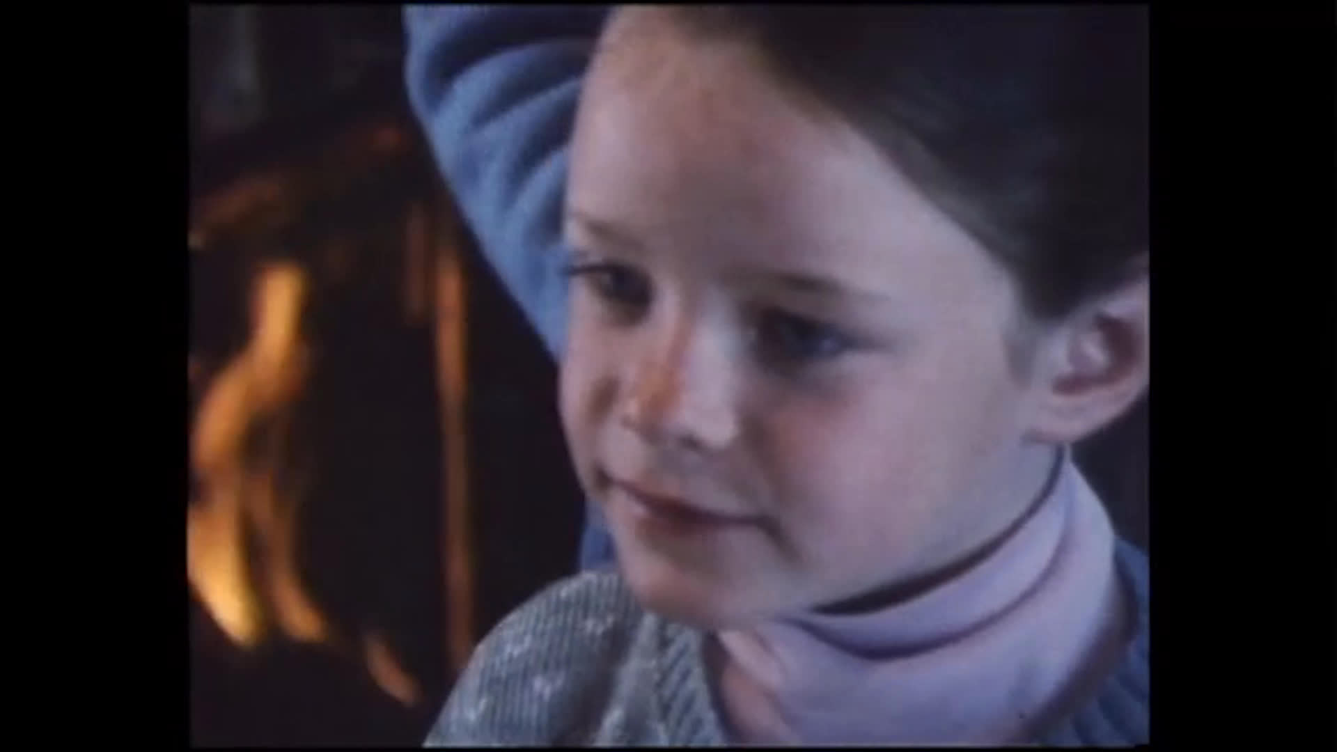 A woman brushes a young girl’s hair beside a brick fireplace as they talk. The girl practices saying “chickadees” and repeats a reminder to finish homework before other activities.