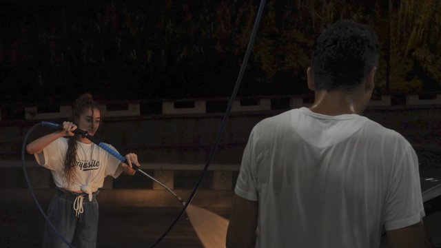 Woman spraying a man with water