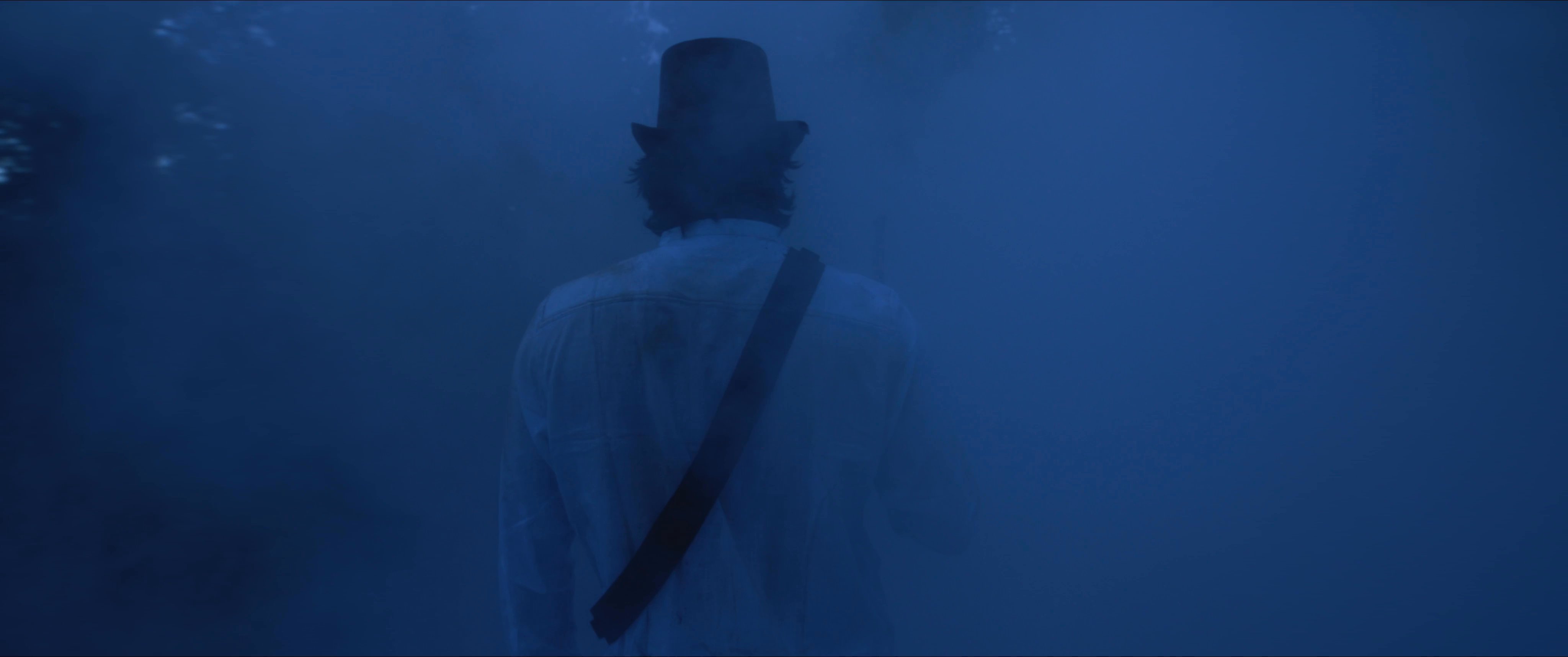 A soldier navigates through a dense, blue-toned fog, transitioning into a surreal encounter with a man in a top hat before awakening to view a glowing smartphone screen.