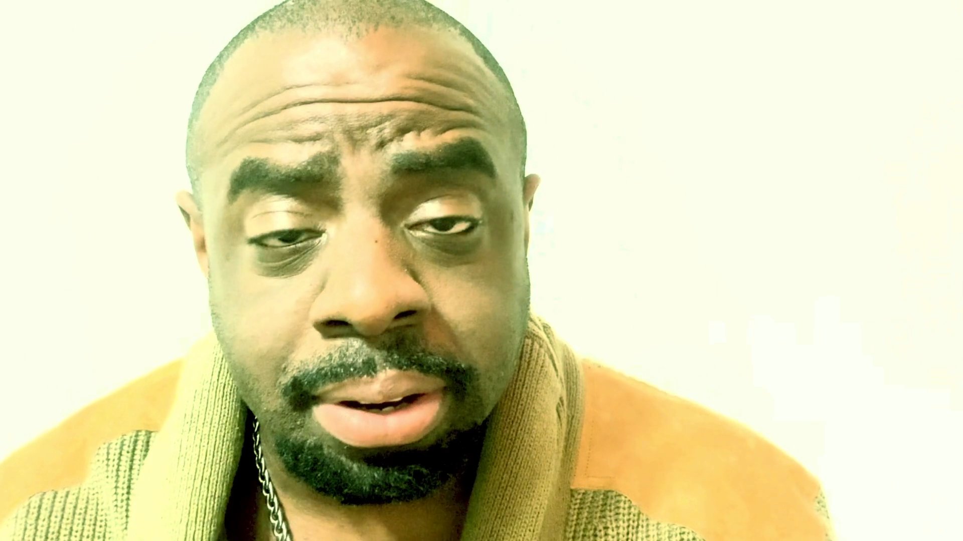 A man addresses the camera with thoughtful and emotive expressions while engaged in a nuanced, conversational monologue.