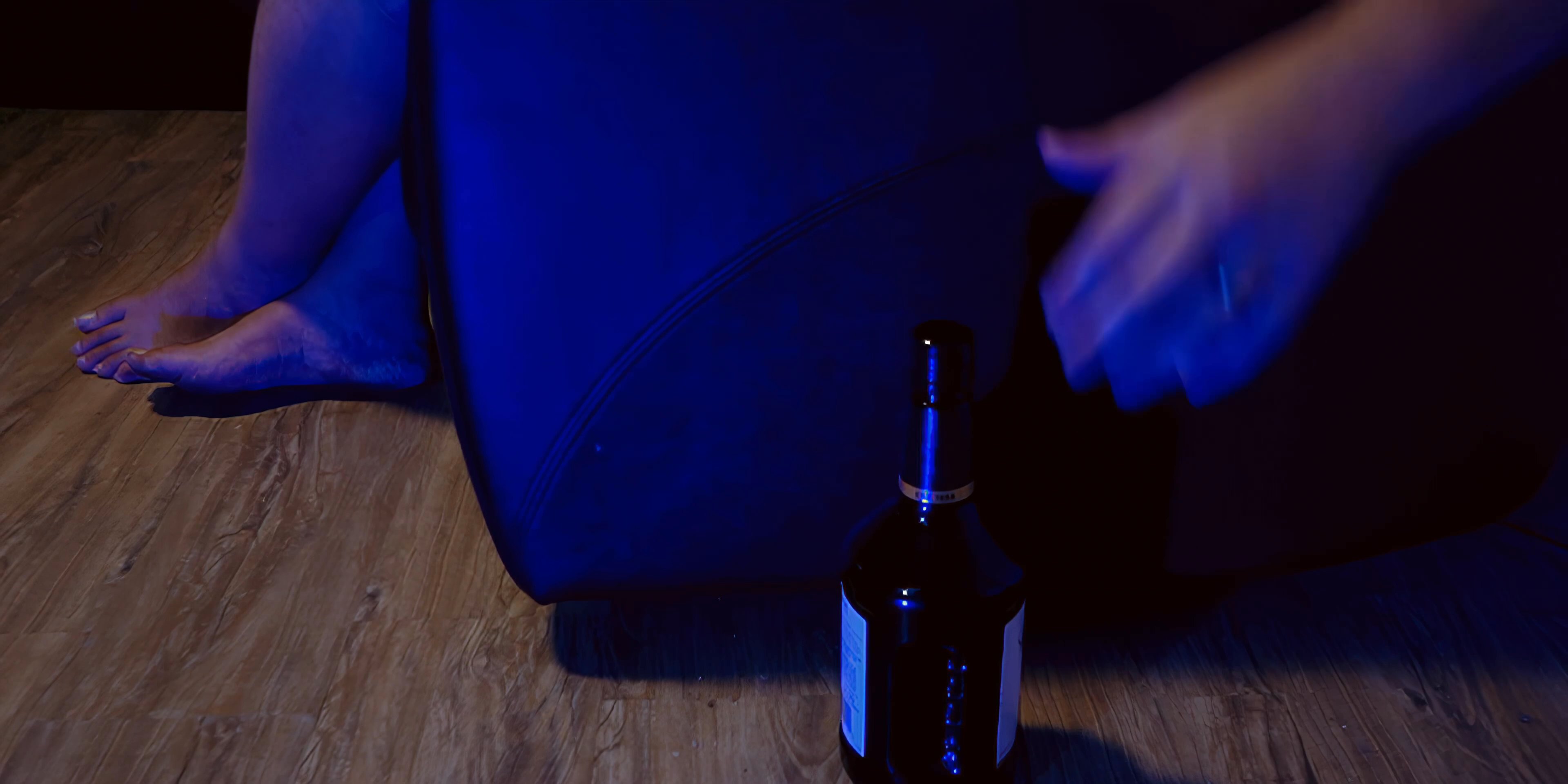 A man sits in a recliner during the evening, eating food and drinking from a glass before eventually showing signs of exhaustion. He reflects on his day in a quiet, dimly lit domestic setting.