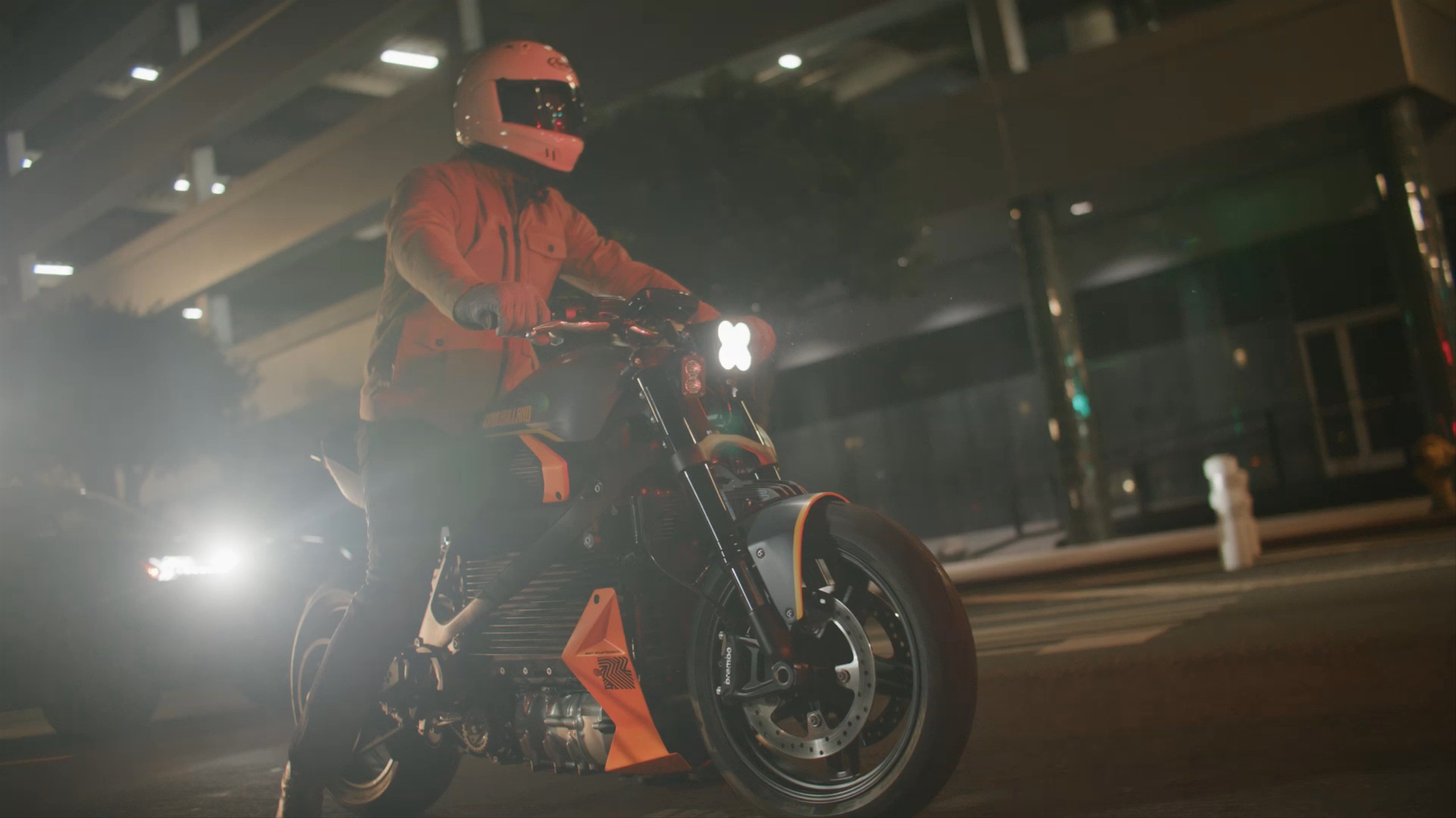 Man on motorcycle at night pulling up to intersection in slow motion 