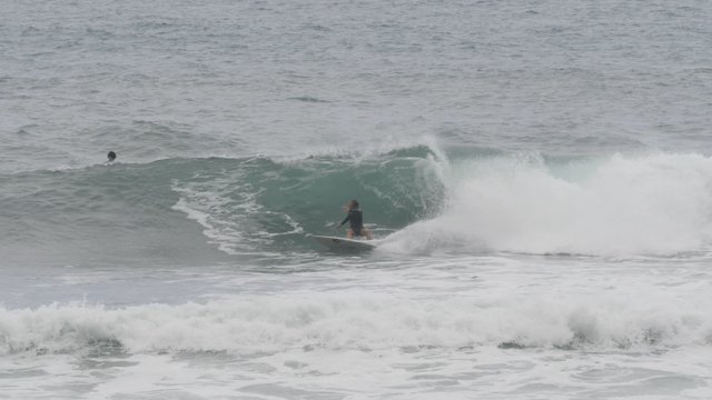 Waves crashing as a man surfs