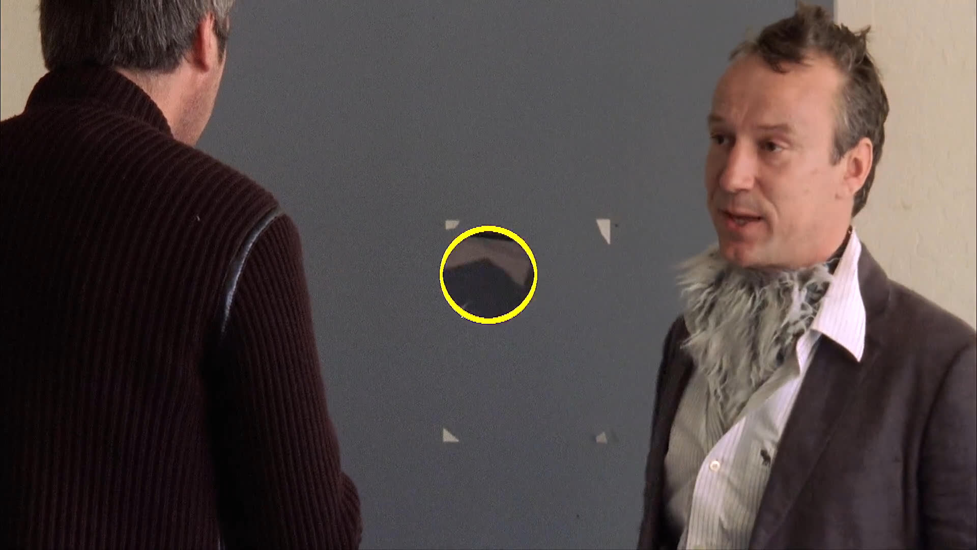 Two men engage in a professional discussion that transitions into a bizarre scenario involving a person in a dog costume and a cleanup operation in an outdoor public space.