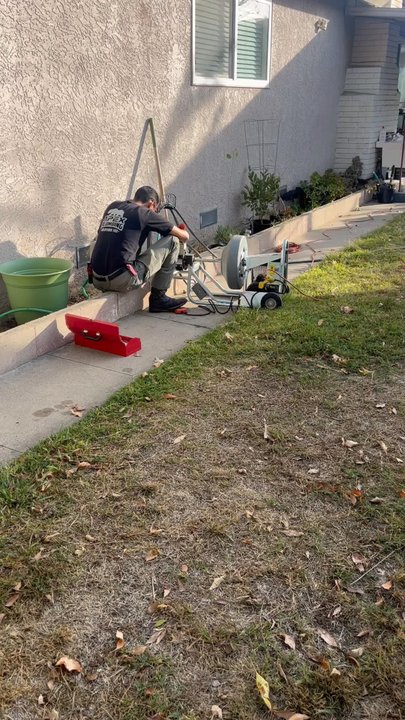 Apex Plumbing Solutions - Running automatic cable through outside sewage pipe to unclog pipes - Plumbing Near Me