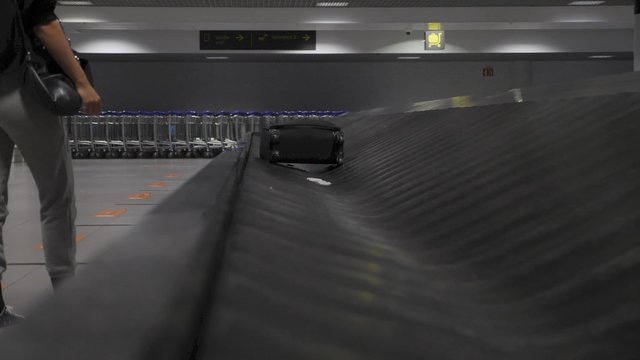 Picking up suitcase from luggage carousel