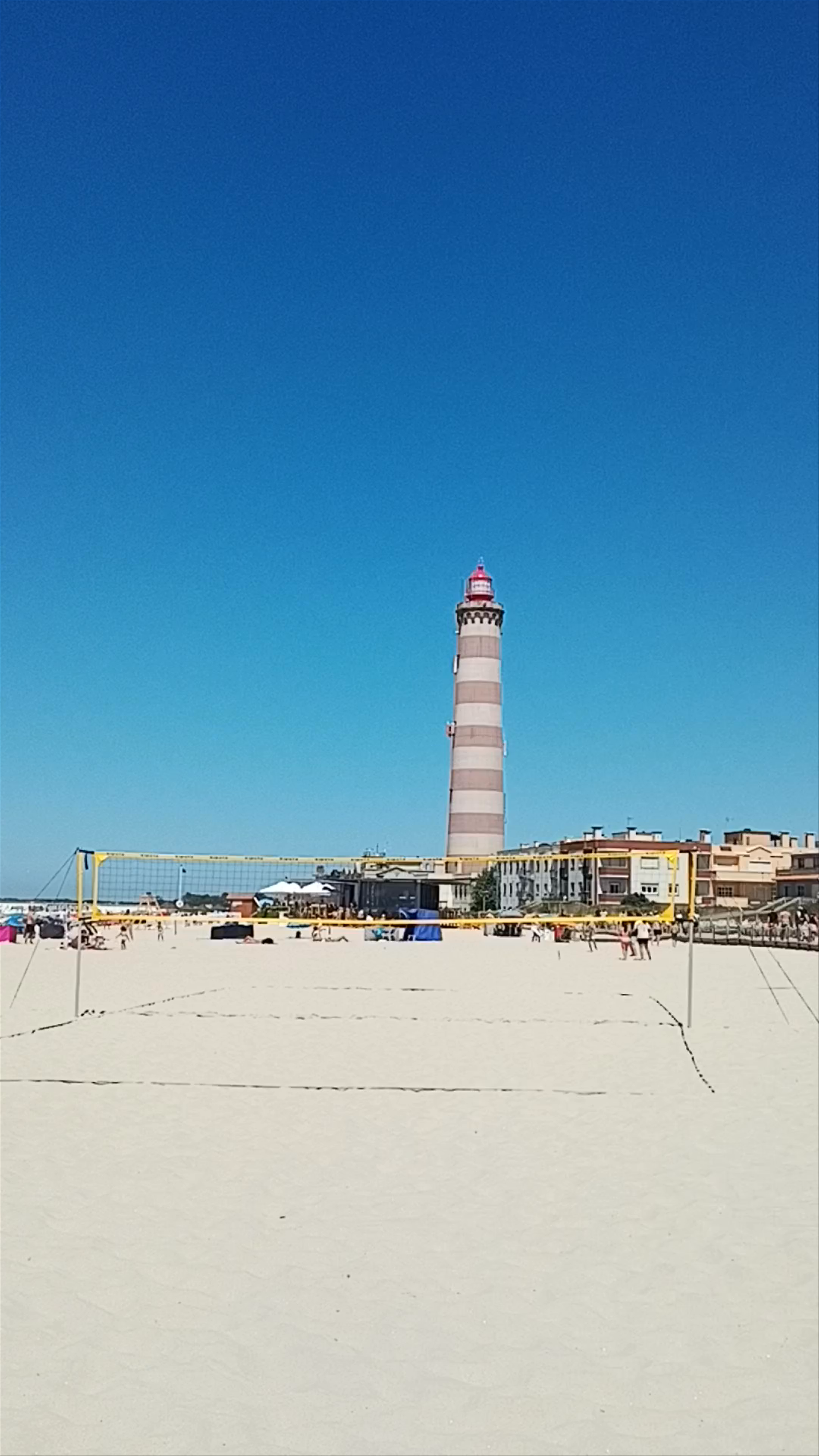 Sunny Beach Day at Praia da Costa Nova with Iconic Lighthouse Views