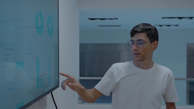 A young man presenting results in a meeting
