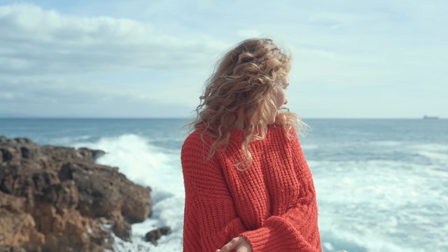 A happy girl smiling while standing at the coast
