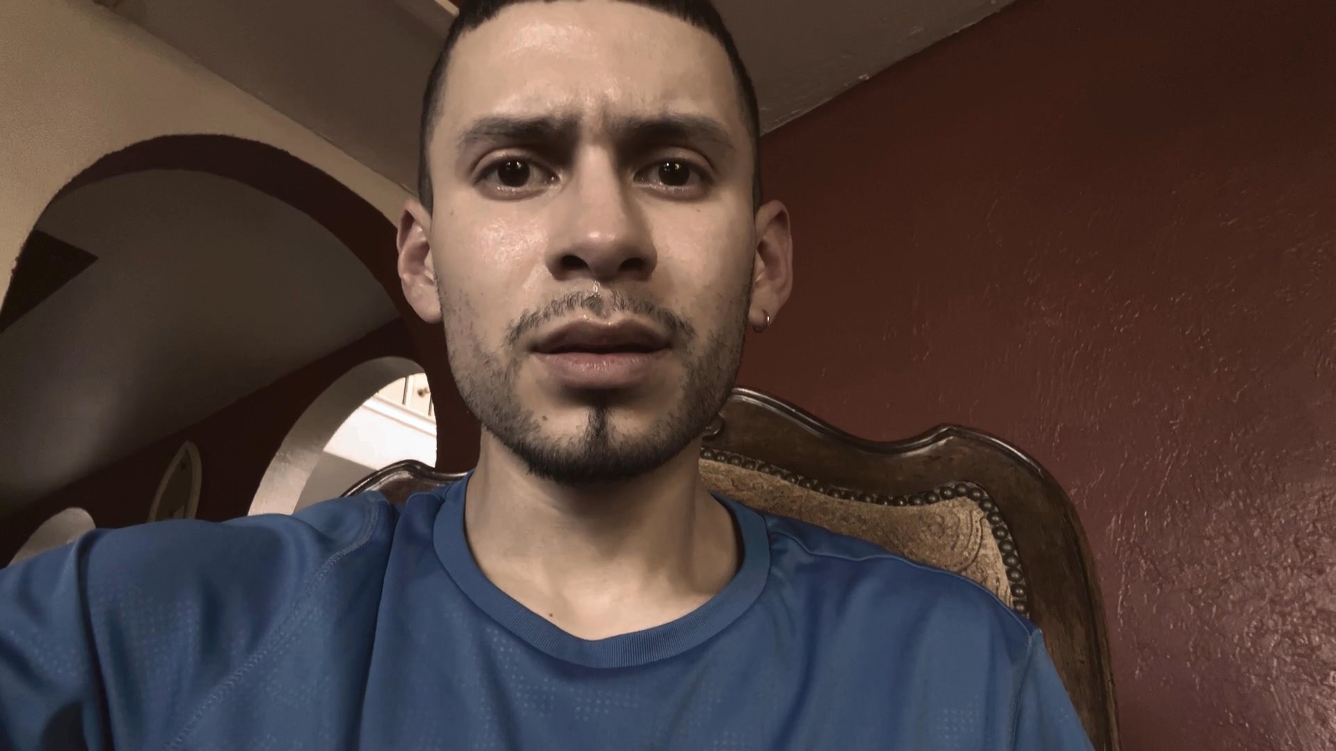 A man speaks directly to the camera in a close-up, personal setting, providing commentary or sharing a message with his audience.