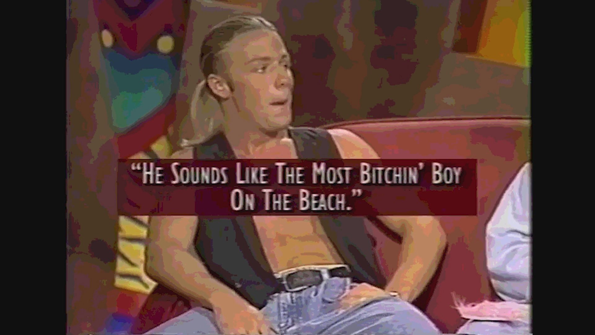 A woman and a man engage in a lively conversation on a television talk show set, with on-screen captions detailing their remarks.