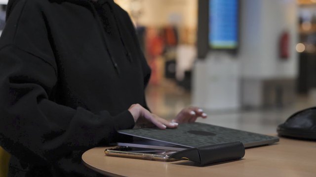 Woman opens laptop at airport