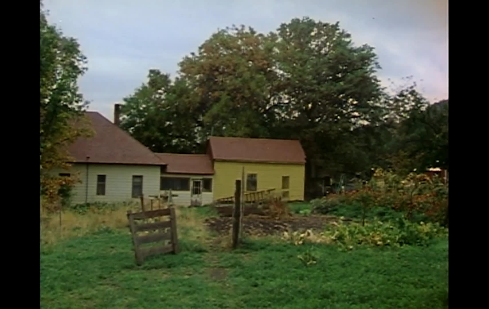 Ranchers handle cattle in a livestock pen, move around a barnyard, and gather coats and produce at home. A rancher describes the financial pressures of operating year to year with bank loans and borrowed machinery.