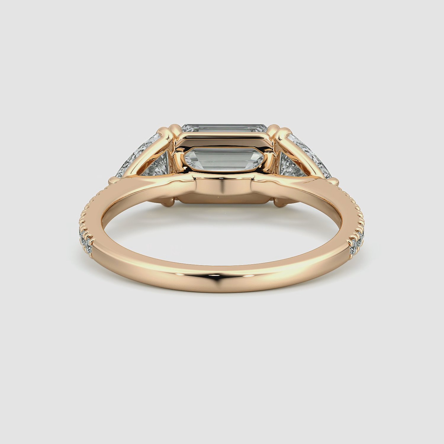 The Three Stone | Emerald | 14k | Rose Gold | bandAccent: Pavé | diamondOrientation: horizontal | sideStoneCarat: 0.50ct | sideStoneShape: Trillion | caratWeight: other