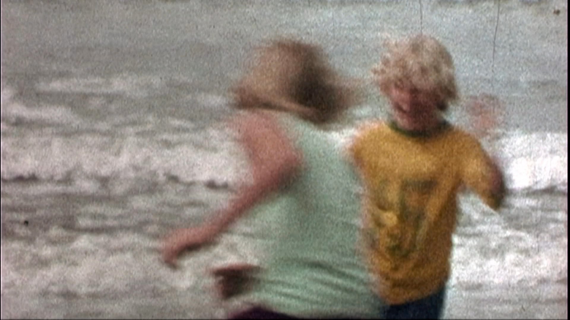 Musicians perform on stage, interspersed with vintage home movie footage capturing family moments at the beach, go-karting, and casual social gatherings.