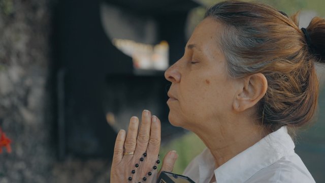 A close-up of a woman praying