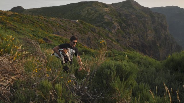 Man running with a dog on a mountain 