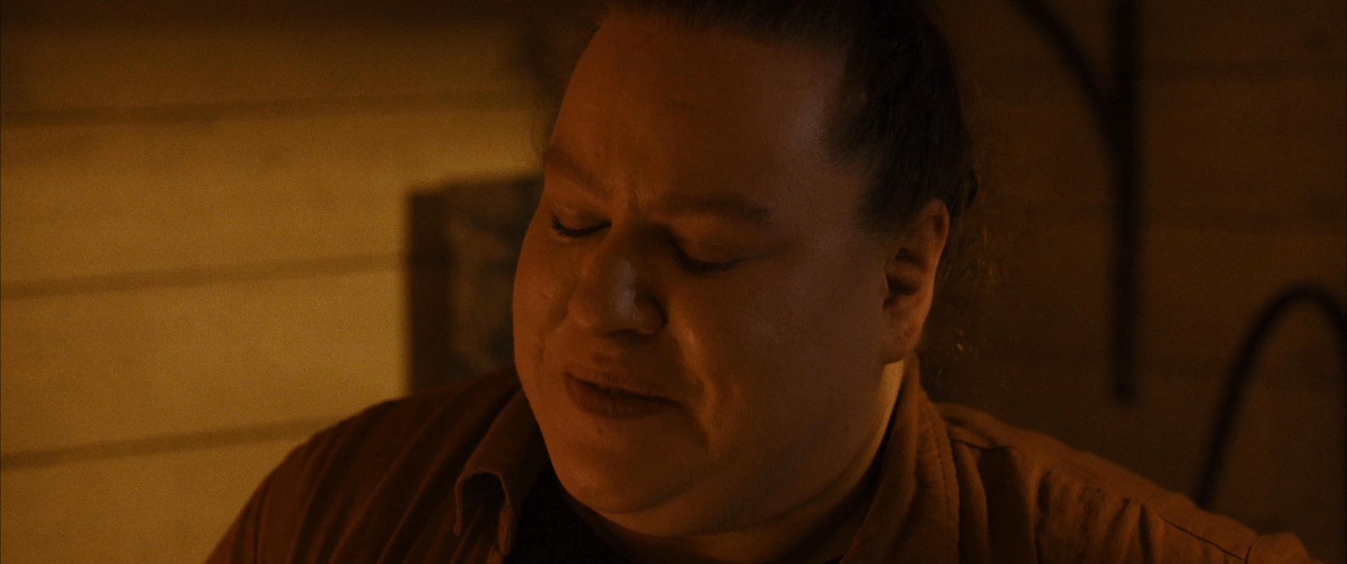 A man scrolls through a digital photo gallery on his smartphone, displaying various emotional expressions while viewing the images. The scene transitions between close-ups of the device interface and the man's contemplative face in a dimly lit environment.