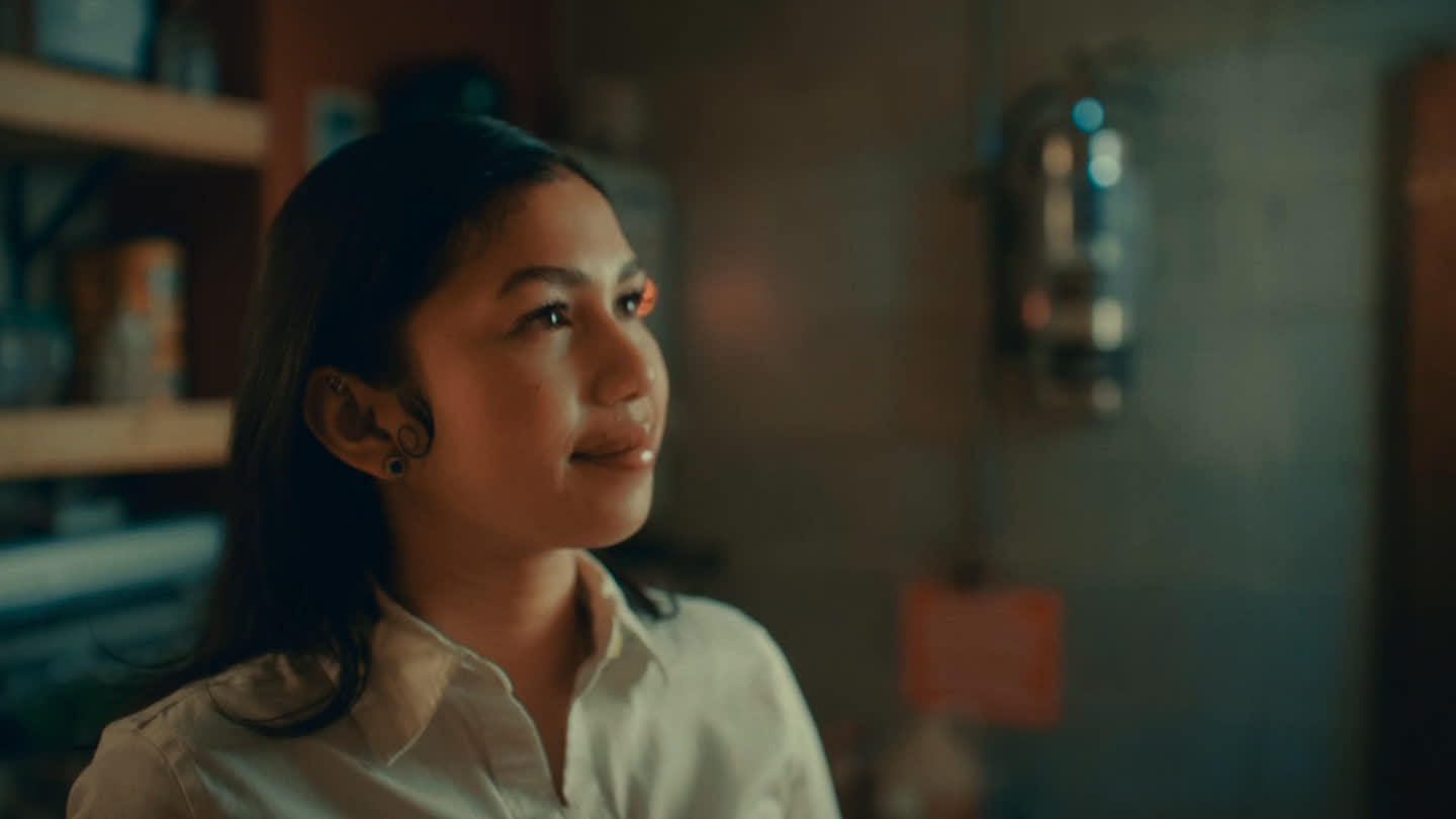 Film still: a café worker looking up with a relaxed expression