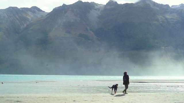 Woman with dog near mountains