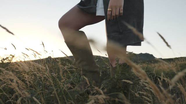 Woman running her hands along the grass