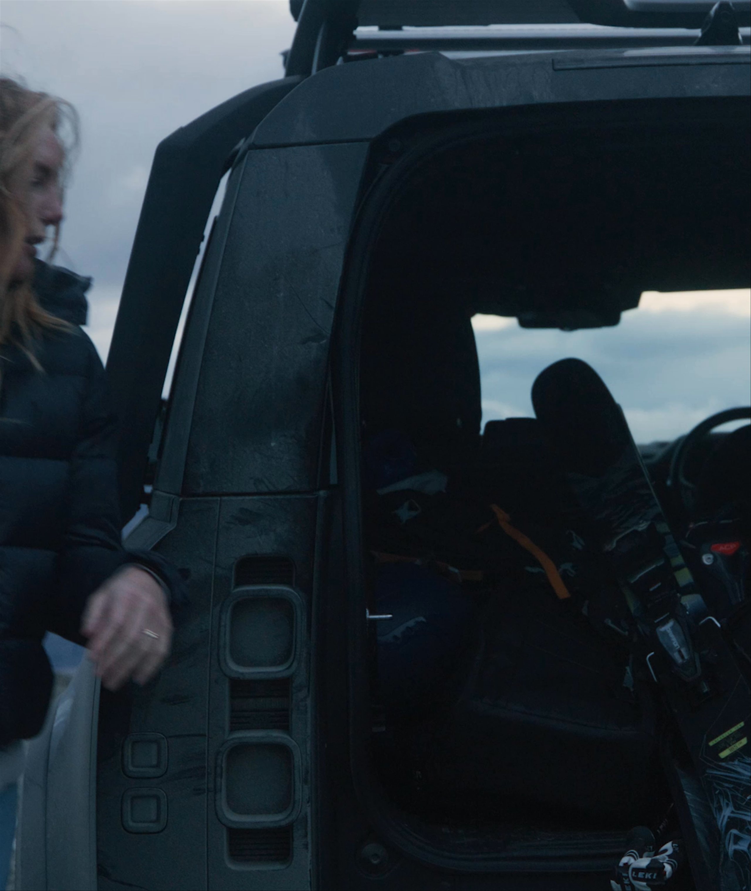 Woman pulling skis out from back of car