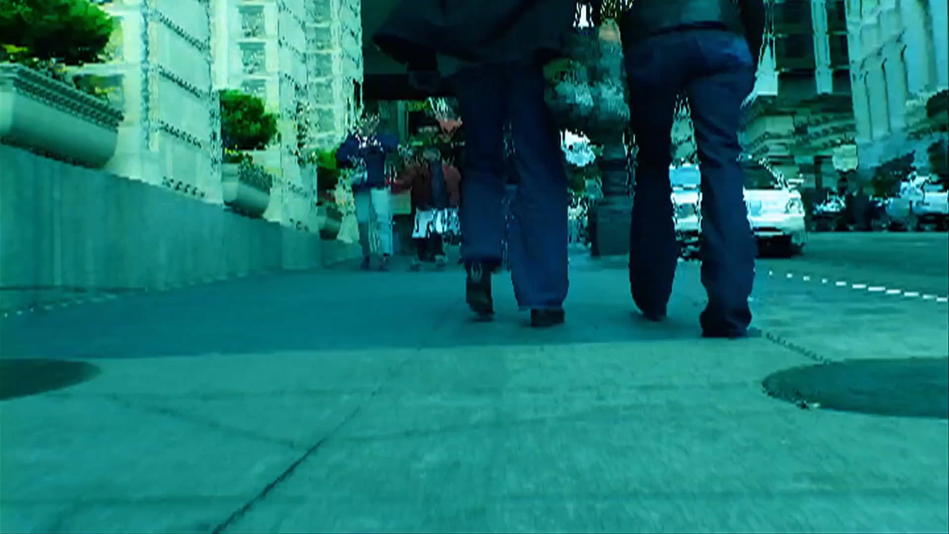 Foot traffic moves along busy city sidewalks and across intersections before transitioning to the interior of a grocery store where a person walks with a golden retriever.