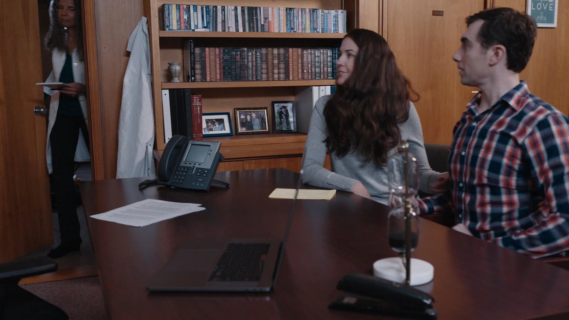 Two individuals meet with a healthcare professional in an office setting to discuss medical information and receive guidance. The session involves a collaborative exchange regarding personal health matters.