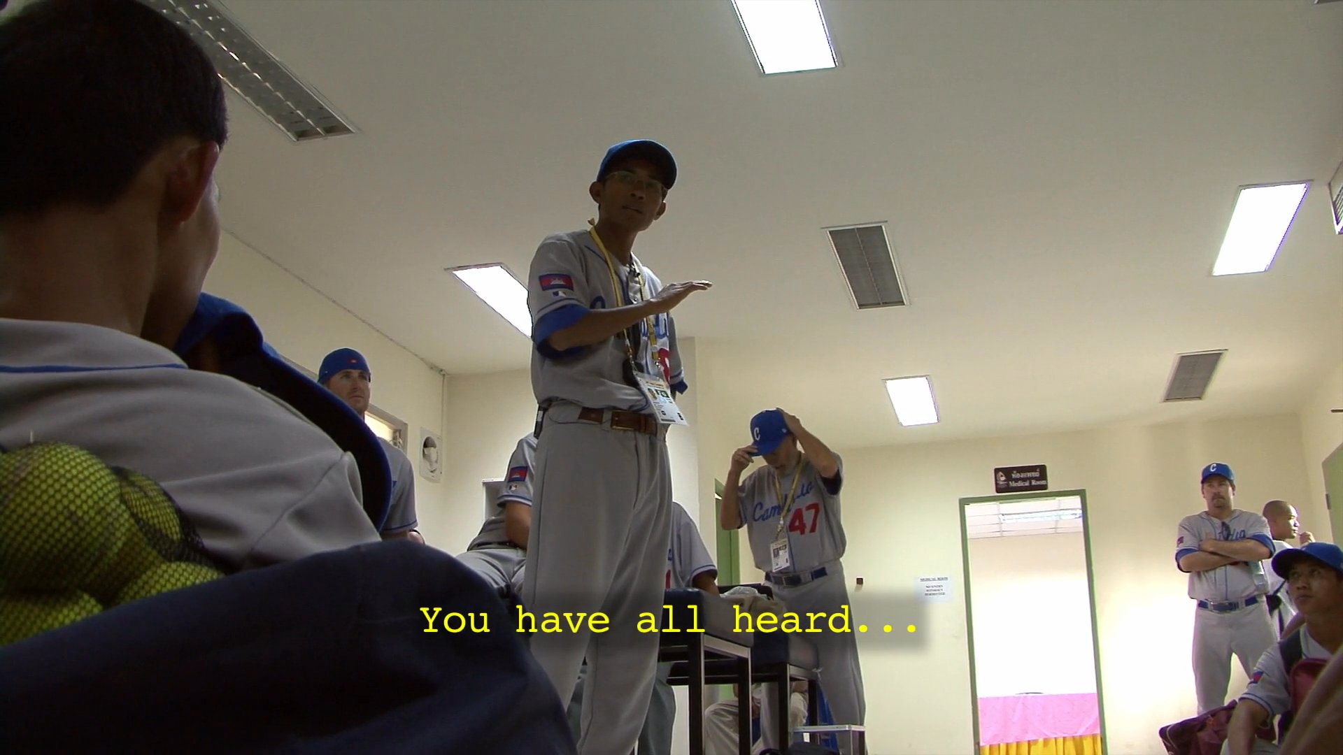 A coach delivers a motivational briefing to the Cambodia national baseball team, emphasizing a shift in mindset before an upcoming game against the Philippines.