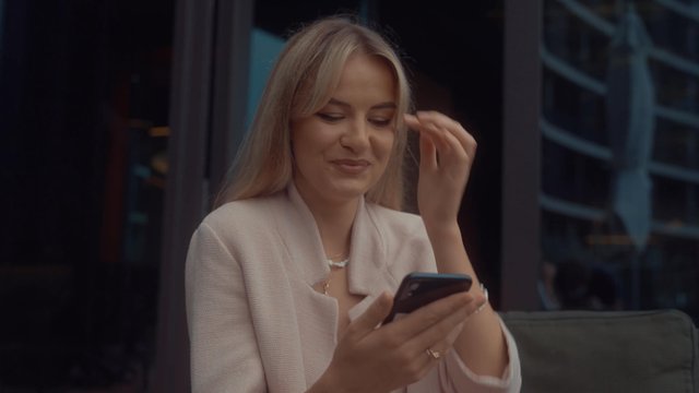 A woman smiling while using her smartphone