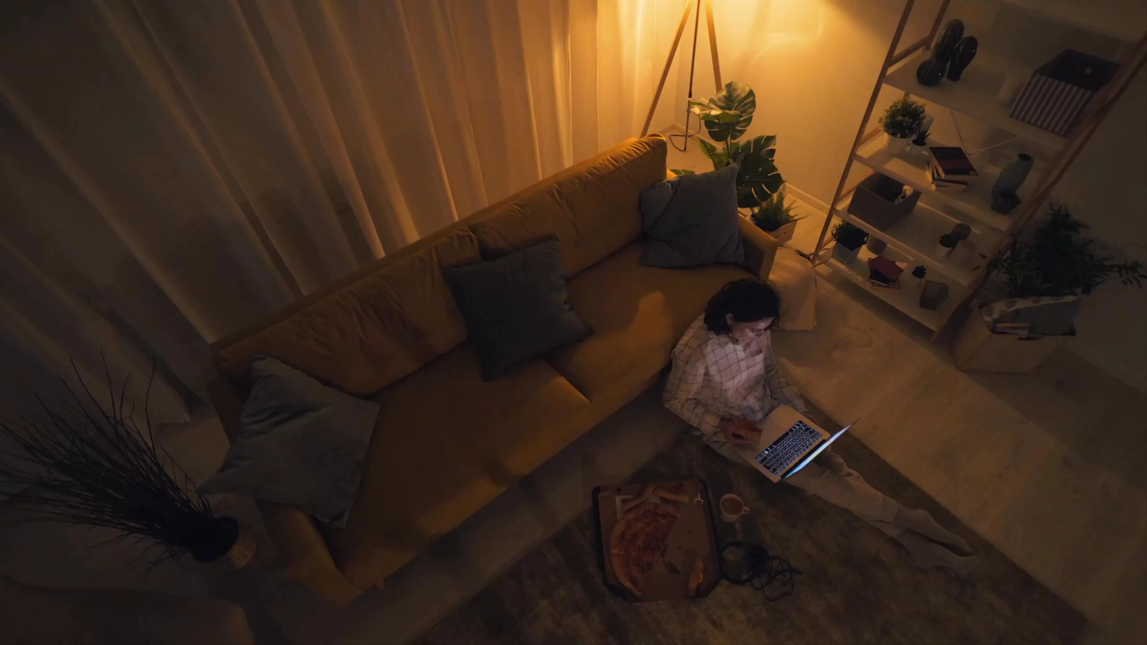 Woman eating pizza on laptop